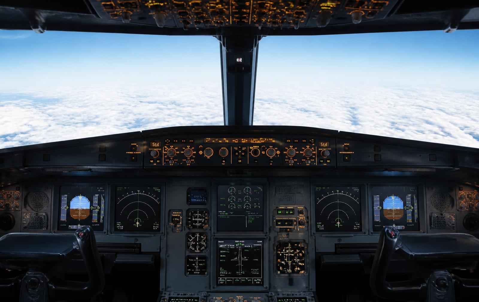 Cabina de vuelo de un avión comercial sobre las nubes